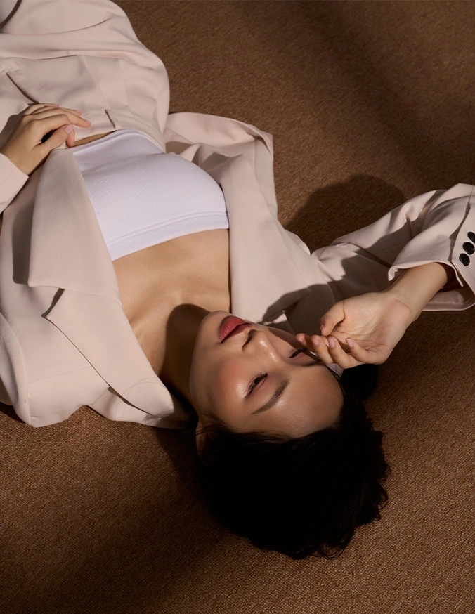Person lying on floor reading book in white shirt with dramatic lighting and shadows