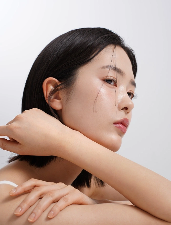 Asian woman with clear skin touching neck and shoulder in beauty skincare portrait